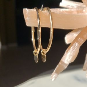 Gold hoop earrings with small disc dangle